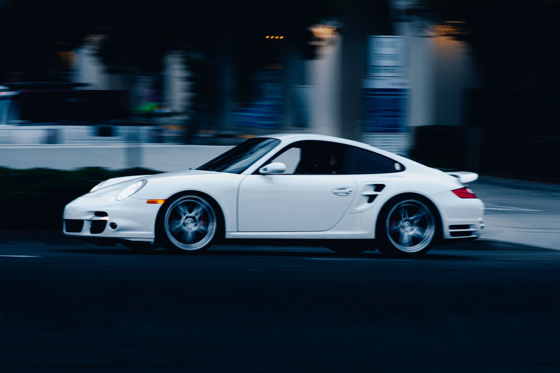 White sports car in motion on a city street