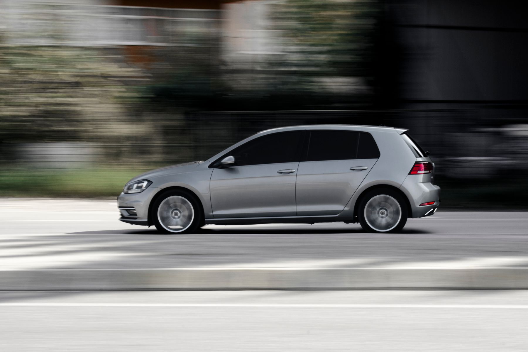 Silver five-door hatchback in motion, side profile