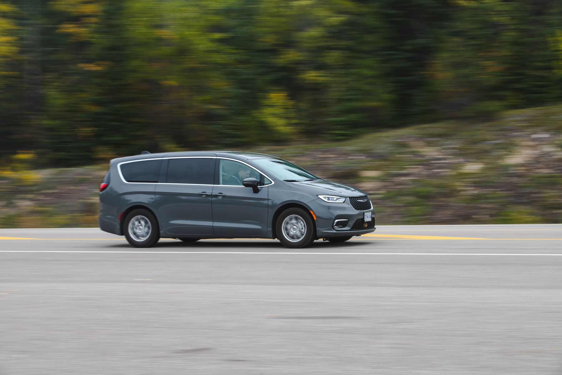 Gray Chrysler Pacifica minivan in motion, side profile