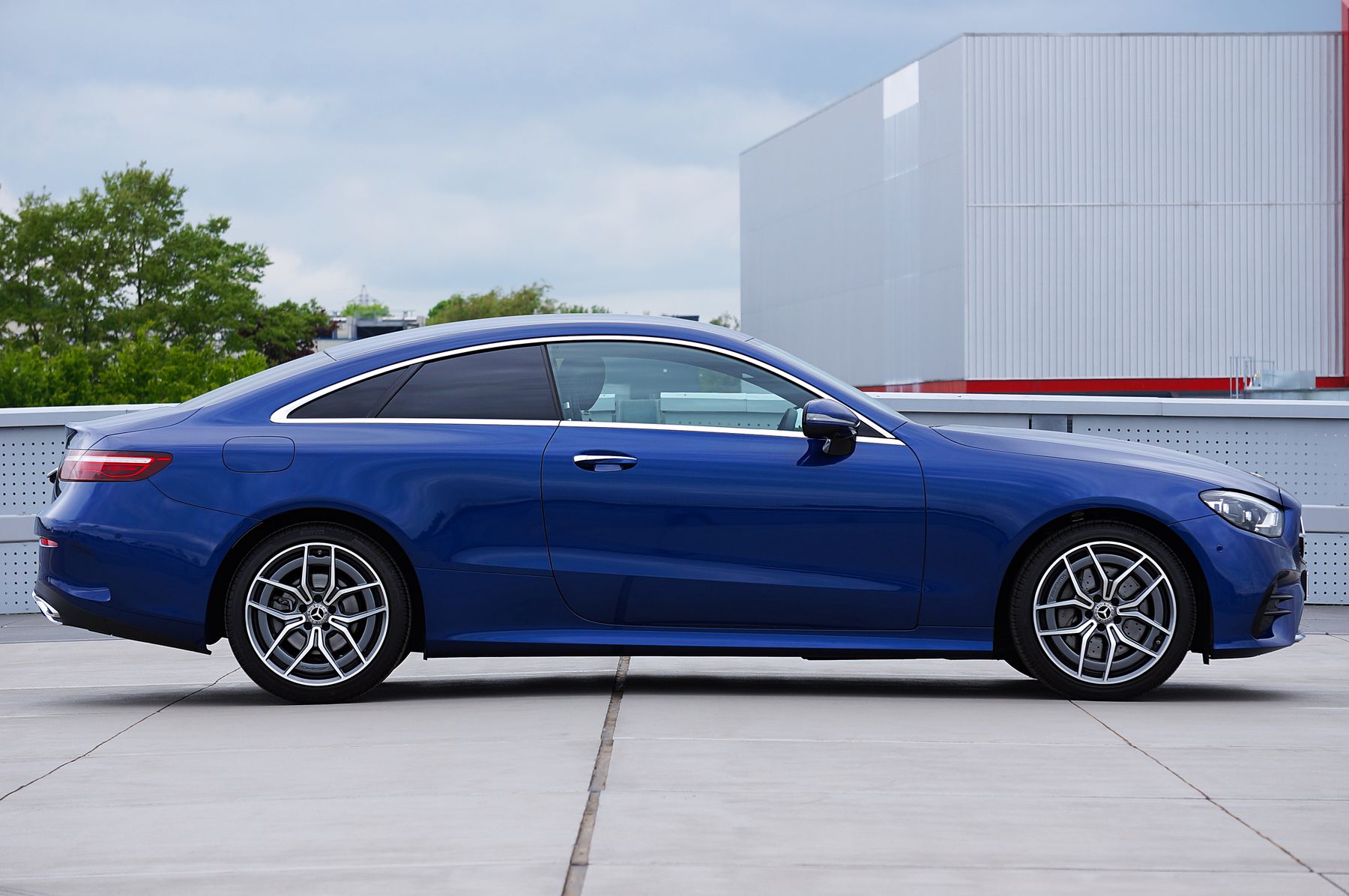Blue Mercedes-Benz E-Class sedan in side profile