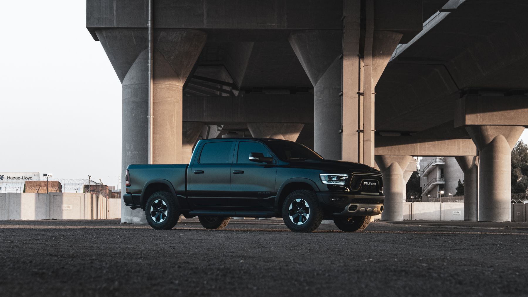 Black Ram 1500 pickup truck parked under a concrete overpass